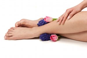 Pedicured feet, manicured hands and aromatic flowers in a spa